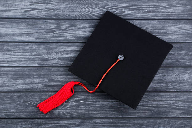 istock Graduation cap on black wooden table 1159582723