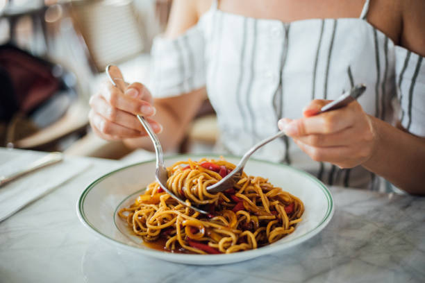 kobieta jedząca pyszne, skupić się na dłoni - pasta tubes zdjęcia i obrazy z banku zdjęć