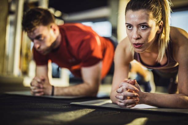 istock Athletic couple exercising strength in plank position at gym. 1159585597