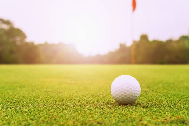 istock golf ball on green grass with sunrise 1159585961
