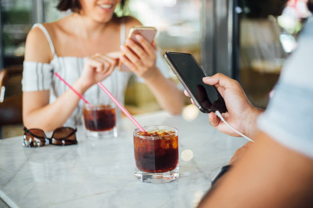 istock Couple of young people drinking coffee and using smartphone 1159586069