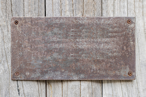 Rusted metal plates on the old wooden background