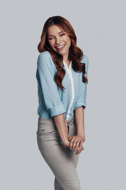 istock So beautiful! Attractive young woman smiling while standing against grey background 1159588728