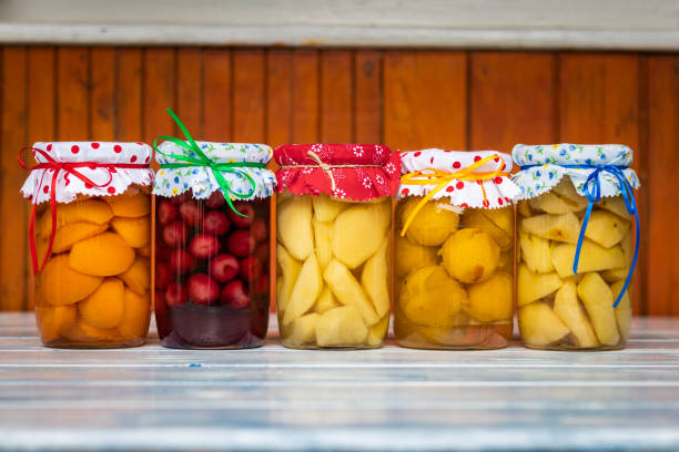 Variety of homemade preserved fruit in kitchen. Apricot, cherry, pear, plum and apple compotes