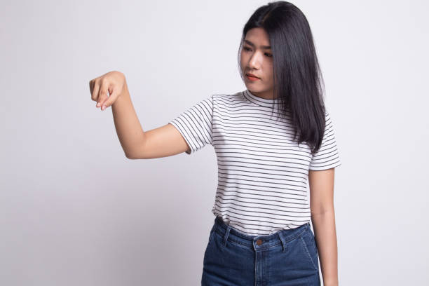 istock Beautiful young Asian woman point down to blank space. 1159590678