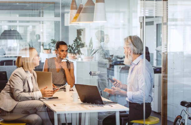 istock Business People Sitting at Desk, Discussing 1159591390