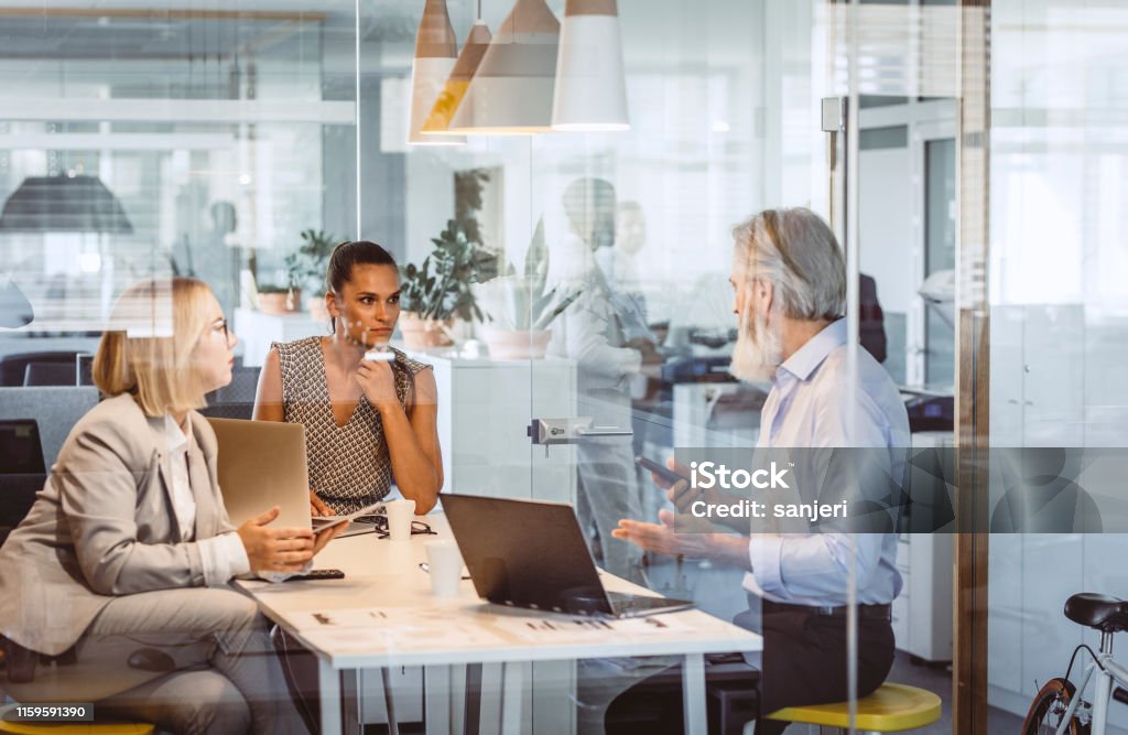 Business People Sitting at Desk, Discussing Office Stock Photo