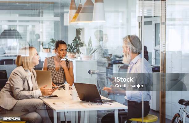 Business People Sitting At Desk Discussing Stock Photo - Download Image Now - Office, Business, Financial Advisor