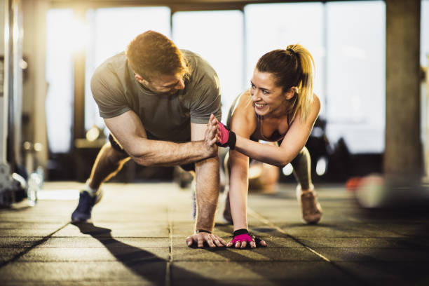 istock Young happy athletes giving each other high-five while doing push-ups in a health club. 1159593721