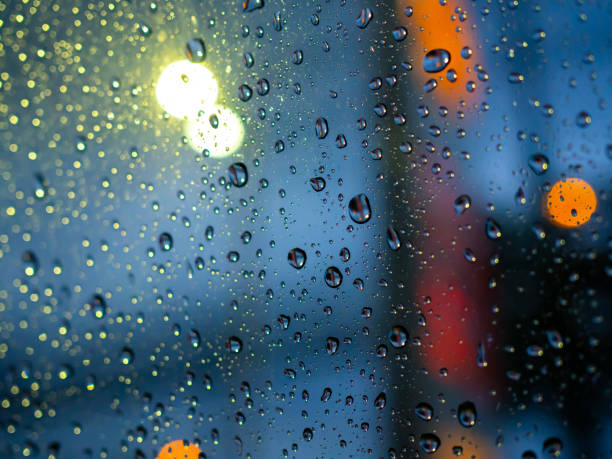 istock Rain drops texture on car window with colorful bokeh abstract background. 1159594451