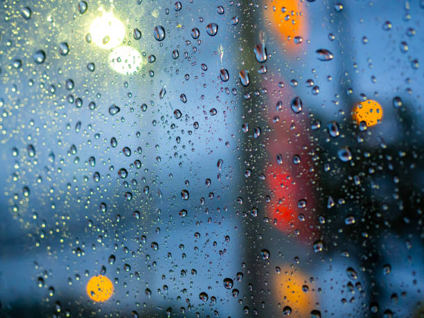 istock Rain drops texture on car window with colorful bokeh abstract background. 1159594484