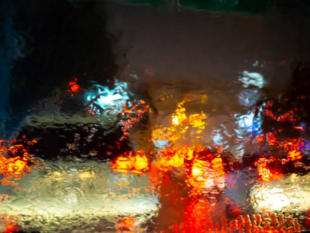 istock Rain drops texture on car window with colorful bokeh abstract background. 1159594532