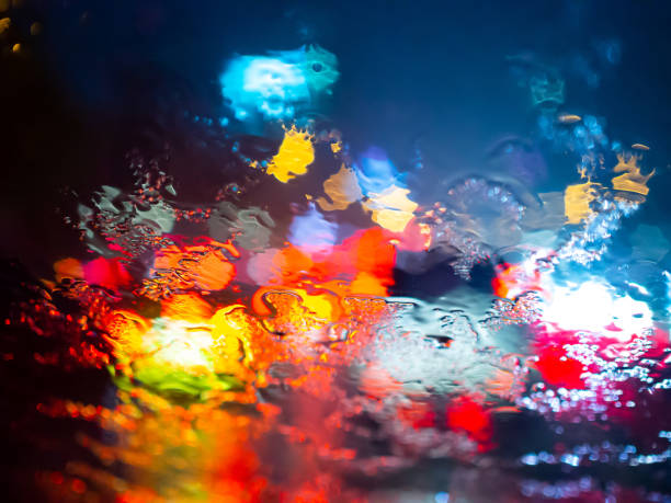 istock Rain drops texture on car window with colorful bokeh abstract background. 1159594533