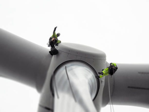 istock Two Rope access technician doing blade inspection on wind turbine and doing gesture 1159594804