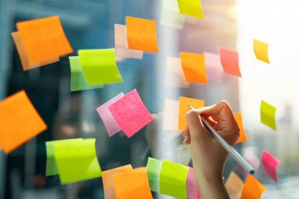 istock Young businesswoman working with stickers note on glass window 1159594839