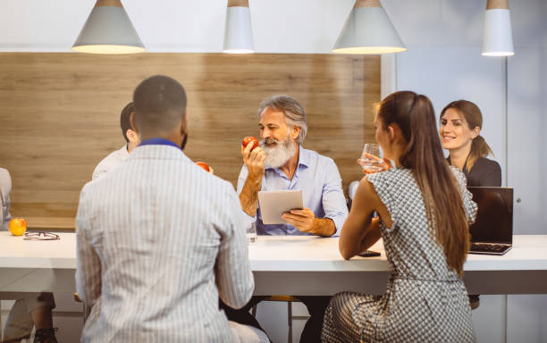 istock Business People Having a Break, Discussing Around The Table 1159596473