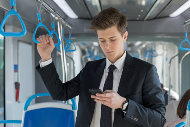 istock Businessman with phone in train 1159596566