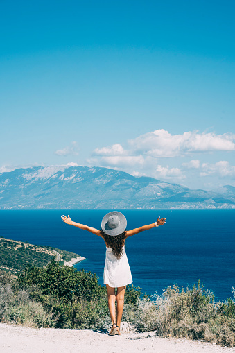 Rear view of woman standing on top, panoramic view to Zakynthos island.