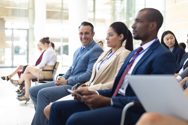 istock Group of diverse executives sat in conference room, smiling to camera 1159600163