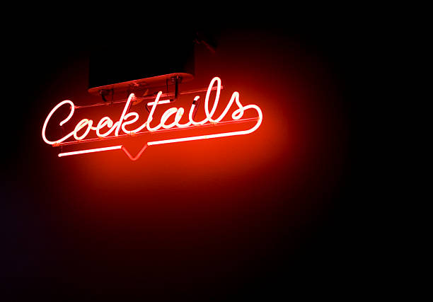 Red neon cocktails sign surrounded by darkness stock photo