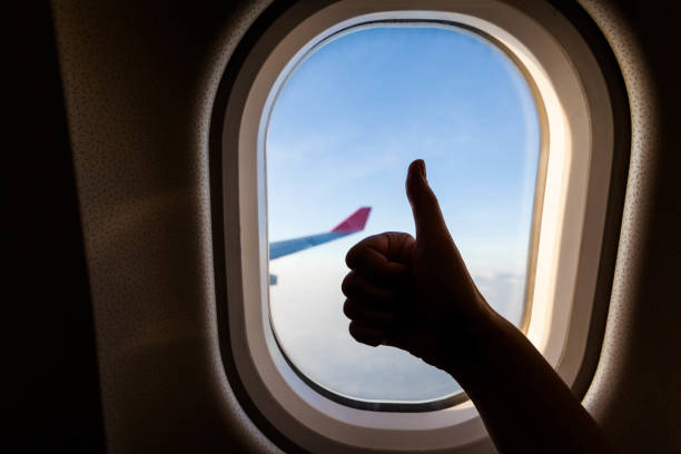 istock Plane wing view from inside plane in midair with blue sky cloud background 1159603433