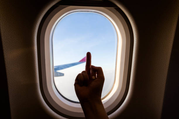 istock Plane wing view from inside plane in midair with blue sky cloud background 1159603460