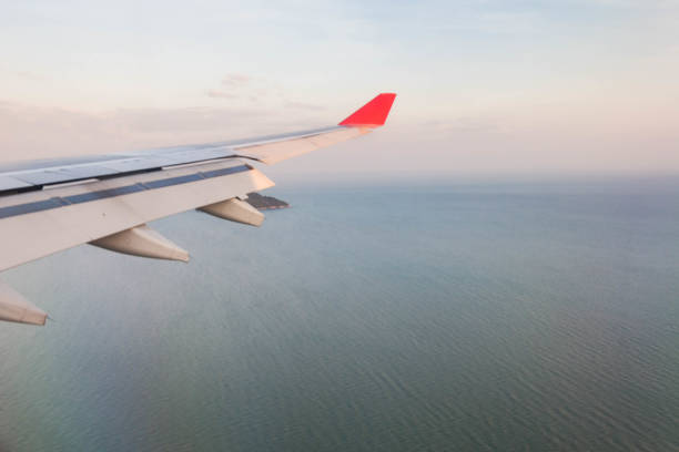 istock Plane wing view from inside plane in midair with blue sky cloud background 1159603475