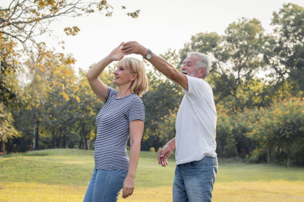 istock Senior couples dance together in the park. 1159604160