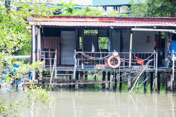 istock Wooden house by the river side view indicating poverty 1159604747