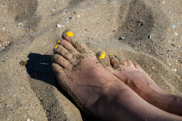 istock Woman's feet on a sea sand on the beach 1159606206