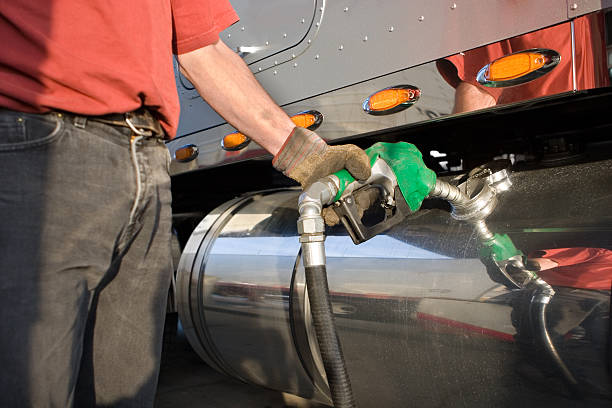 A man fueling a gas tank of a truck Diesel Fuel Pump, Semi Truck fuel storage tank photos stock pictures, royalty-free photos & images