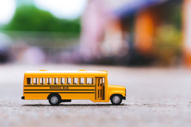 miniatura dello scuolabus giallo sulla strada - school bus defocused education bus foto e immagini stock