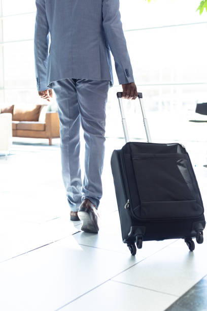 istock Young African-american male executive walking with suitcase 1159607899