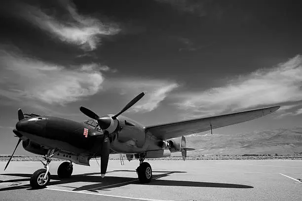 World War II vintage Army P-38 Lightning.  Image desaturated except for miniature Japanese flags denoting enemy aircraft shot down.