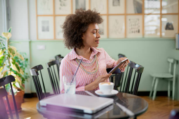 istock Woman using tablet in coffee shop. 1159608612