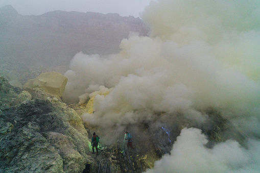 Ijen, Java, Indonesia, 20th April 2019: Man extinguish blue fire in Ijen volcano and sulphur minings