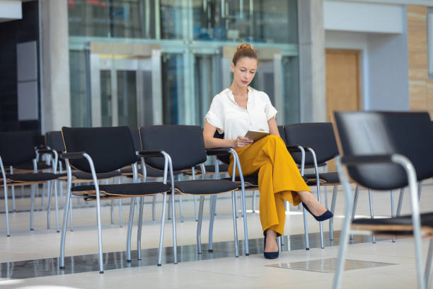 istock Caucasian female executive looking at digital tablet while sitting on chair in empty conference room 1159609777