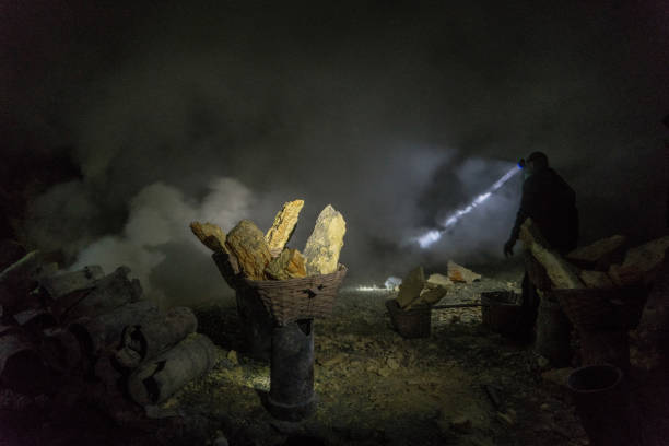 istock Man with flashlight in  Ijen volcano and sulphur minings 1159609979