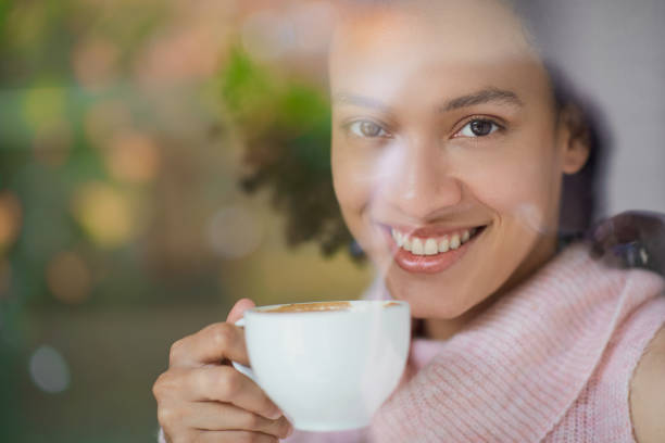 istock Woman standing near cafe window and drinking coffee. 1159611788