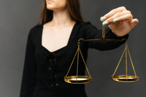 istock Serious woman holding the justice scale on dark background 1159614137