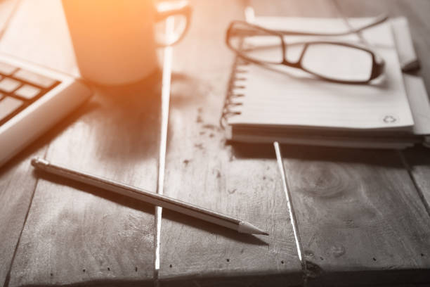 Notebook, laptop,glasses and cup of coffee with cactus on wood table with copy space