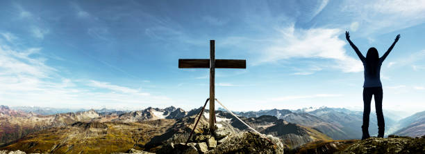 happy woman at summit cross in swiss alps