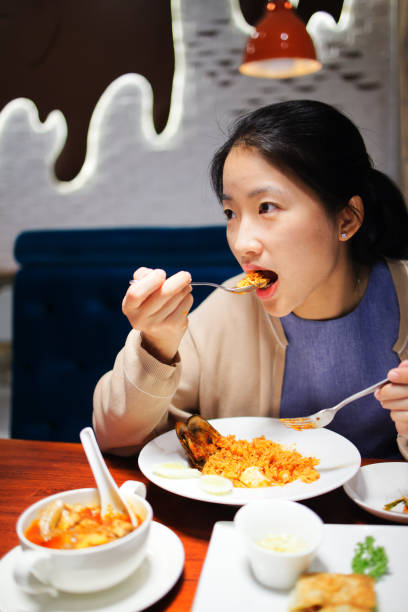 istock Asian woman is eating spicy fired rice in restaurant. 1159619937