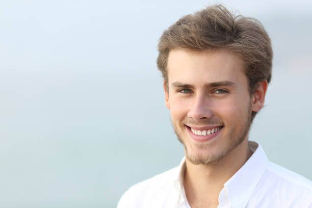 istock Portrait of a happy man looking at camera on the beach 1159619965