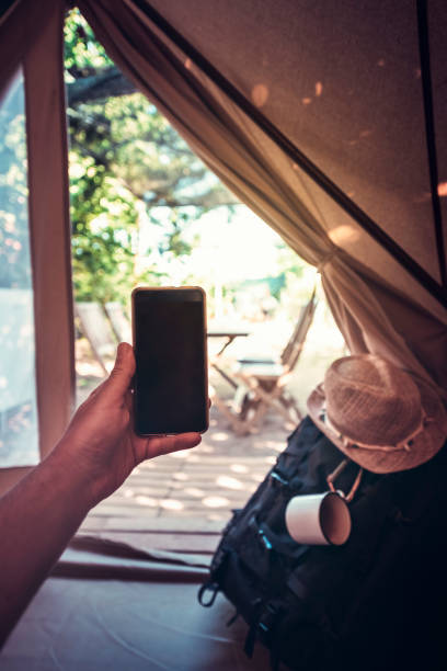 istock hand of a man with a phone in camping tent 1159620325