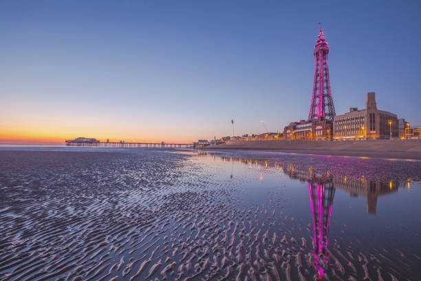 Blackpool and Blackpool Tower at Dusk. Summer 2019. View of Blackpool the North pier and Blackpool Tower at Dusk taken from the Beach.. Summer 2019. lancashire photos stock pictures, royalty-free photos & images
