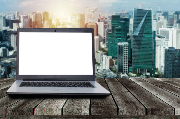 istock laptop notebook computer with white blank screen on desk with during sunrise and cityscape background, advertisement, workspace, internet technology, online social media and searching data concept 1159622622
