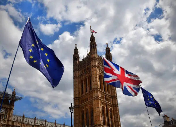 The European Union and UK flags flying outside tje House of Parliament in London as part of a Brexit protest