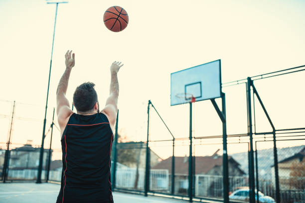istock Male Basketball Player Practicing Shooting The Ball 1159624829