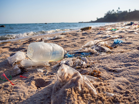 Garbage on the beach. Spilled garbage on the beach of the big city. Empty used dirty plastic bottles. Dirty sea sandy shore the Black Sea. Environmental pollution. Ecological problem.